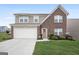 Charming two-story home showcasing a brick and siding exterior, landscaped yard, and a two-car garage at 1560 Avalon Creek Rd, Sugar Hill, GA 30518