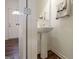 Clean powder room with a pedestal sink, decorative towels, and stylish flooring at 1560 Avalon Creek Rd, Sugar Hill, GA 30518
