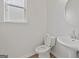 A modern half bathroom offers a pedestal sink, toilet and window for natural light at 4003 Garden Ln, College Park, GA 30337