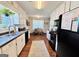 Bright kitchen with white cabinets, black appliances, and a view to the eat-in area at 1741 Portwest Way, Hampton, GA 30228
