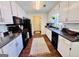 Galley kitchen with white cabinets, dark countertops, and modern appliances at 1741 Portwest Way, Hampton, GA 30228