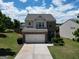 Beautiful two-story home with a two-car garage and well-manicured lawn against a sky with scattered clouds at 1369 Star Water Dr, Lawrenceville, GA 30045