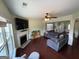 Comfortable living room featuring a fireplace, hardwood floors, a large sectional couch and bright windows at 1369 Star Water Dr, Lawrenceville, GA 30045