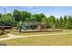 A playground area with swings, slides, and climbing structures surrounded by green trees at 1369 Star Water Dr, Lawrenceville, GA 30045
