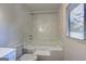 Bright bathroom with a shower-tub combo and a window at 50 Caroline Ave, Stockbridge, GA 30281