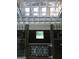 Barn interior featuring wooden horse stalls with decorative metal gates under a beamed ceiling with windows at 155 Green Meadow Ln, Fayetteville, GA 30215