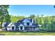 Stunning two-story home featuring a metal roof, inviting porch, and lush greenery at 155 Green Meadow Ln, Fayetteville, GA 30215