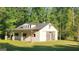 Exterior view of barn with porch featuring stone columns surrounded by lush green landscape at 155 Green Meadow Ln, Fayetteville, GA 30215
