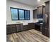 Modern kitchen with stainless steel appliances, dark cabinets, farmhouse sink, and a large picture window at 155 Green Meadow Ln, Fayetteville, GA 30215