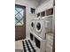 Bright laundry room features front load machines, ample storage, and a stylish Buffalo check rug at 155 Green Meadow Ln, Fayetteville, GA 30215