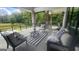 Covered patio with comfortable seating, outdoor views, stone columns, and black metal railing at 155 Green Meadow Ln, Fayetteville, GA 30215