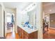 Bathroom featuring double sinks, a large mirror, wood cabinets, and hardwood floors at 3006 Gold Creek Dr, Villa Rica, GA 30180