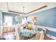 A dining room with blue walls, modern table and chairs, and a decorative light fixture at 3006 Gold Creek Dr, Villa Rica, GA 30180
