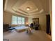 Spacious bedroom featuring a tray ceiling, large windows, and a cozy sitting area with modern decor at 1345 Cashiers Way, Roswell, GA 30075
