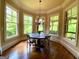 Sunlit breakfast nook featuring hardwood floors, a round table and large windows overlooking the greenery at 1345 Cashiers Way, Roswell, GA 30075