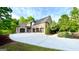 A three-car garage is attached to this brick house with a driveway winding to the street at 1345 Cashiers Way, Roswell, GA 30075
