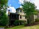 Rear view of a brick home with a screened porch, lush landscaping, and a well-manicured lawn at 1345 Cashiers Way, Roswell, GA 30075
