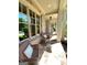 Charming covered porch with stone flooring, comfortable seating, and views of the landscaped yard at 1345 Cashiers Way, Roswell, GA 30075