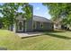 Back exterior view shows a patio, chimney, and lush green lawn, creating a comfortable outdoor space at 135 Gingercake Ct, Fayetteville, GA 30214
