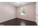 Cozy bedroom with a window, dark wood-look floors, and neutral walls at 135 Gingercake Ct, Fayetteville, GA 30214