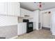 Traditional kitchen features white cabinets, tile floors, and a black range oven at 135 Gingercake Ct, Fayetteville, GA 30214