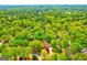 An aerial view of a neighborhood reveals lush, green trees surrounding homes in a private setting at 8575 Haven Wood Trl, Roswell, GA 30076