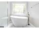 Spa-like bathroom featuring a freestanding tub and a decorative stained glass window at 8575 Haven Wood Trl, Roswell, GA 30076