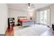 Serene bedroom featuring hardwood floors, a ceiling fan, and bright natural light at 8575 Haven Wood Trl, Roswell, GA 30076