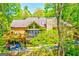 A wooded exterior showcases a large back porch and upper deck that overlook a peaceful forest at 8575 Haven Wood Trl, Roswell, GA 30076