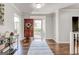Inviting foyer with hardwood floors, decorative rug, and view of the front door at 8575 Haven Wood Trl, Roswell, GA 30076