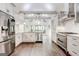 Bright, renovated kitchen with stainless steel appliances, white cabinetry and hardwood floors at 8575 Haven Wood Trl, Roswell, GA 30076