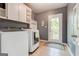 Functional laundry room with modern washer and dryer, built-in cabinets, and access to outdoor deck at 8575 Haven Wood Trl, Roswell, GA 30076