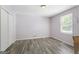 Simple bedroom with wood-look floors, ample natural light, and a spacious closet at 6942 Cottonwood Trl, Riverdale, GA 30296