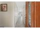 Bright hallway with wood-look tile leading to the kitchen and featuring a decorative wood front door at 6942 Cottonwood Trl, Riverdale, GA 30296