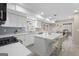 Open kitchen with island, stainless steel appliances, white cabinetry, and tile backsplash at 6942 Cottonwood Trl, Riverdale, GA 30296