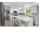 Modern white kitchen with stainless appliances, tiled backsplash, and central island with bar seating at 6942 Cottonwood Trl, Riverdale, GA 30296