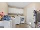 Convenient laundry room with modern washer and dryer, storage cabinets, and practical design at 6942 Cottonwood Trl, Riverdale, GA 30296