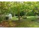 Lush backyard featuring a deck, mature trees, and expansive green space at 17 Hampton Way, Carrollton, GA 30116