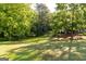 Beautiful backyard with mature trees, green grass, and a gentle slope, perfect for outdoor enjoyment at 17 Hampton Way, Carrollton, GA 30116