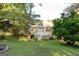 Charming backyard view of home with a deck and stairs surrounded by lush greenery at 17 Hampton Way, Carrollton, GA 30116