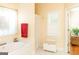 Bright bathroom featuring a soaking tub, window with shutters, and white tile floors at 17 Hampton Way, Carrollton, GA 30116