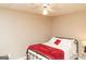 Cozy bedroom with a ceiling fan, wood laminate floors, and a red blanketed bed at 17 Hampton Way, Carrollton, GA 30116