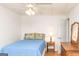 Bedroom with wood floors, ceiling fan, and a blue bed with yellow patterned throw pillows at 17 Hampton Way, Carrollton, GA 30116