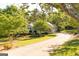 Inviting home exterior with a long driveway, brick facade, black shutters, and mature landscaping at 17 Hampton Way, Carrollton, GA 30116