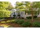 Charming brick home featuring a beautifully landscaped front yard with mature trees and lush greenery at 17 Hampton Way, Carrollton, GA 30116