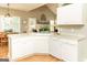Bright kitchen featuring a large sink, dishwasher, and white cabinets overlooking the living room at 17 Hampton Way, Carrollton, GA 30116