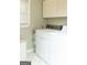 Clean laundry room with white washer and dryer and overhead cabinets at 17 Hampton Way, Carrollton, GA 30116
