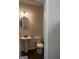 This powder room features a pedestal sink, round mirror, neutral walls and tile floors at 1151 Park Center Nw Cir, Austell, GA 30168