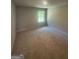 A bedroom with neutral walls and plush carpet, filled with natural light from a single window at 1151 Park Center Nw Cir, Austell, GA 30168