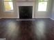 Hardwood floor view of a fireplace with white trim and natural light from surrounding windows at 1151 Park Center Nw Cir, Austell, GA 30168